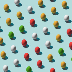 Pattern made of colored eggs on pastel blue background. Minimal food concept.