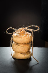 Homemade cookies from сottage cheese and meringue, tied up twine on black slate dish.