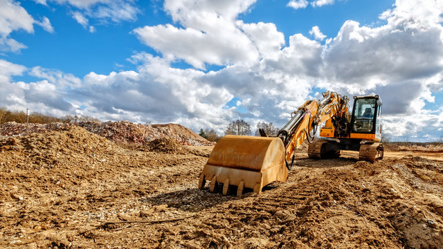bagger mit wolken aif baustelle