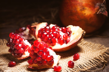 Fresh peeled pomegranates with ruby red beans on old wooden table