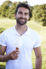 Man smiling with ice cream cone, portrait