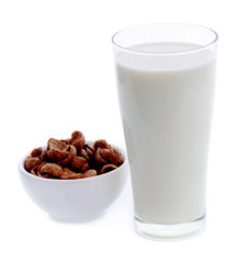 glass of milk and cereals in white bowl on white background
