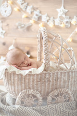 Fototapeta na wymiar Charming baby, sleeping in wicker stroller, cream