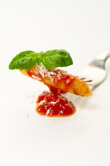 Tasty colorful appetizing cooked spaghetti italian pasta with tomato sauce bolognese and fresh basil on fork. Creative serving, Closeup.