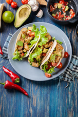 Authentic mexican tacos with chicken and salsa with avocado, tom