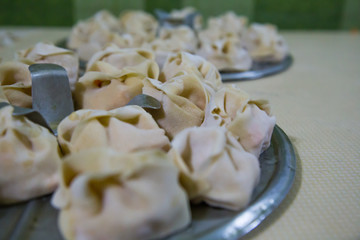 Preparation of manti on a kitchen wooden board. Traditional asian dumplings