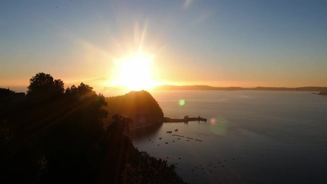 Sunset over the seaside with flare effect. Naples bay and the island of Nisida