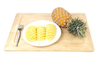 still life of sliced pineapple on desk with knife, on white