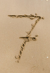 Number 7. Sand Alphabet: digits. Concept holiday background.