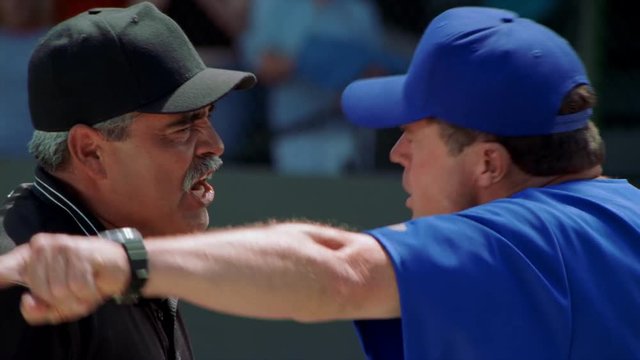 Close-up head-to-head profiles of baseball coach and umpire arguing a call