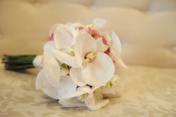 Fototapeta na wymiar Bride's bouquet resting on a white soft cushion