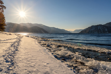 Fototapeta na wymiar lake mountains snow sun footprints