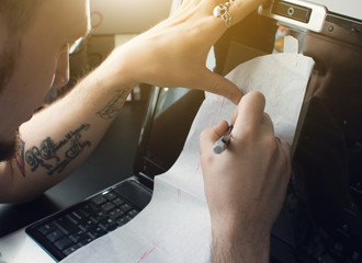 Creating a tattoo close-up. The artist circled the pen with a tattoo sketch on the monitor of his laptop. Draw. Write. To create