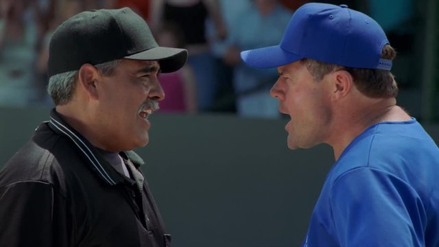 Close-up head-to-head profiles of baseball coach arguing with an umpire, slow motion