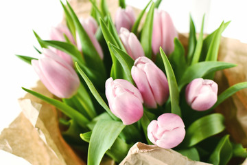 Bouquet of pink tulips in craft brown paper