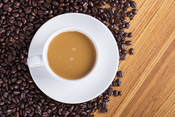 Coffee cup and beans on wooden background