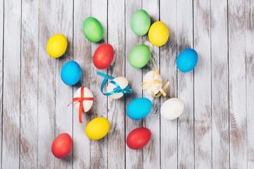Easter card. Scattered colorful Easter eggs on a wooden background.