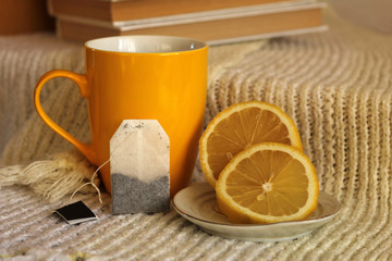 Yellow tea cup, lemon and books