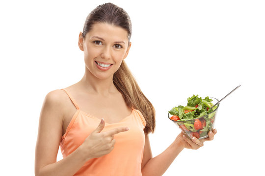 Happy girl holding a salad and pointing
