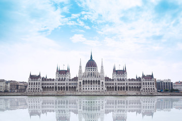 Obraz premium Parliament building in Budapest, Hungary on a cloudy day. Building facade with reflection in water