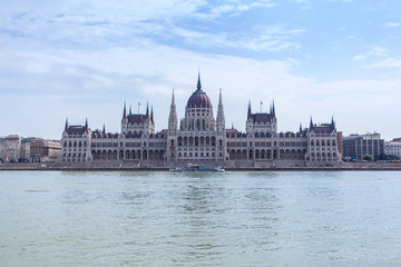Naklejka premium Parliament building in Budapest, Hungary on a cloudy day. Building facade with reflection in water