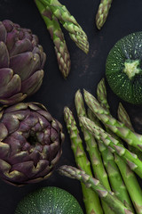 Grüner Spargel, Zucchini und Artischocke auf einem alten rostigen Hintergrund