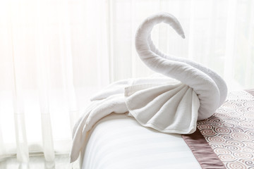 Beautiful swan from white bath towel decorate on bed corner, nice greeting from Hotel.