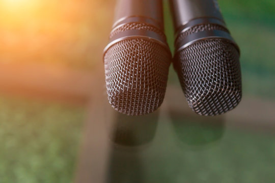 Two microphones with warm fall color and blurred focus in background.