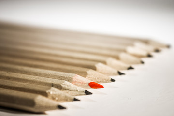 A shallow depth of field closeup photo of a  black and red pencils on a light background