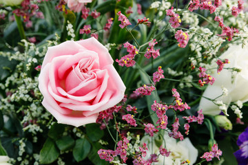 Pink roses arranged in a bouquet of flowers.