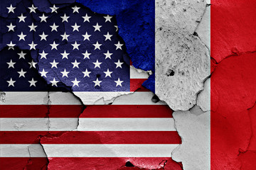 flags of USA and France painted on cracked wall