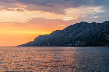 Colorful sunset over the mountain on the Adriatic Sea in Brela, Croatia.
