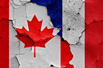 flags of Canada and France painted on cracked wall