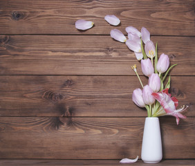 Wooden background witn tulip flowers and amaryllis on vese