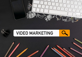 video marketing concept. colorful pencils and a computer keyboard with a mobile phone on a black...