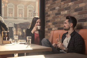 young woman man cafe drinking indoors sunny day window