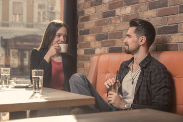 young woman man cafe indoors drinking talking