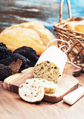 Homemade aromatic butter with black truffles on wooden board.Selective focus.