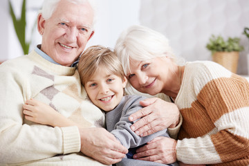 Grandparents embracing their grandson