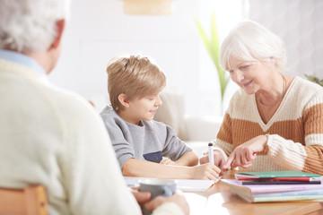 Fototapeta premium Boy doing homework with grandma
