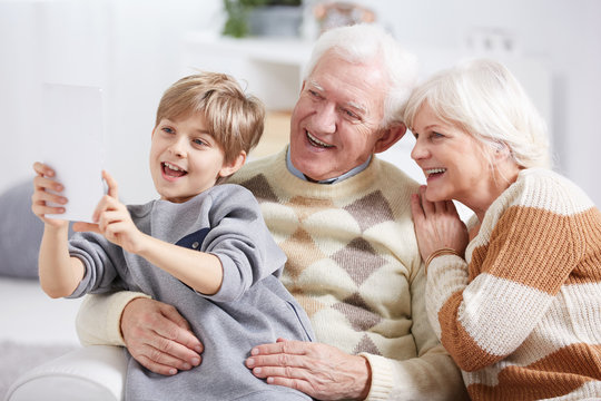 Boy taking selfie with grandparents