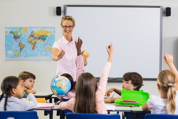 Pupils with hands up during lesson