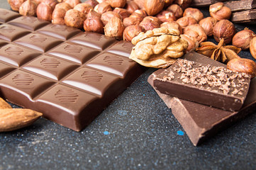 Chocolate pieces, filbert, chocolate shavings, walnut on dark background