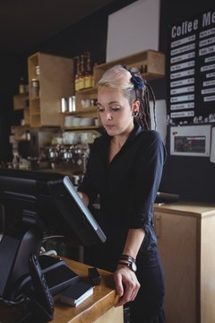 Waitress using cash register at counter