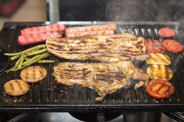 Grilled pork with sausage, mixed grilled vegetables. Aji sauce (chili).