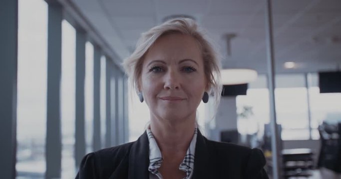Confident mature businesswoman standing in office. Female manager in office looking at camera and smiling.