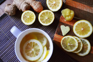 Obraz na płótnie Canvas Ginger tea with lemon in a white cup