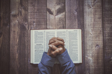 Man praying on a wooded table