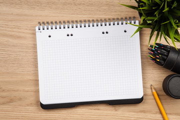 Open notepad with office supplies