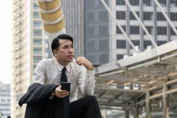 Businessman using smartphone at outdoor of the office building